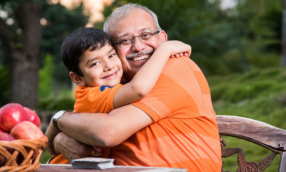 Grandfather hugging young grandson wearing orange t-shirts